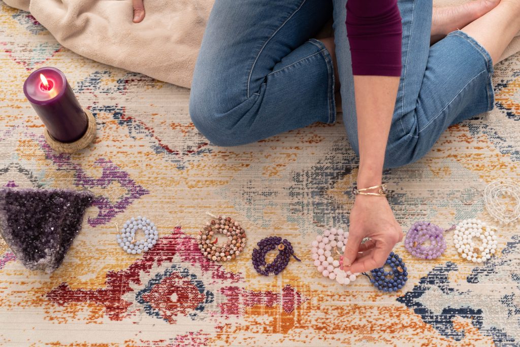 Kathy of Elemental Alchemy with strings of polished gemstones to help focus healing energy